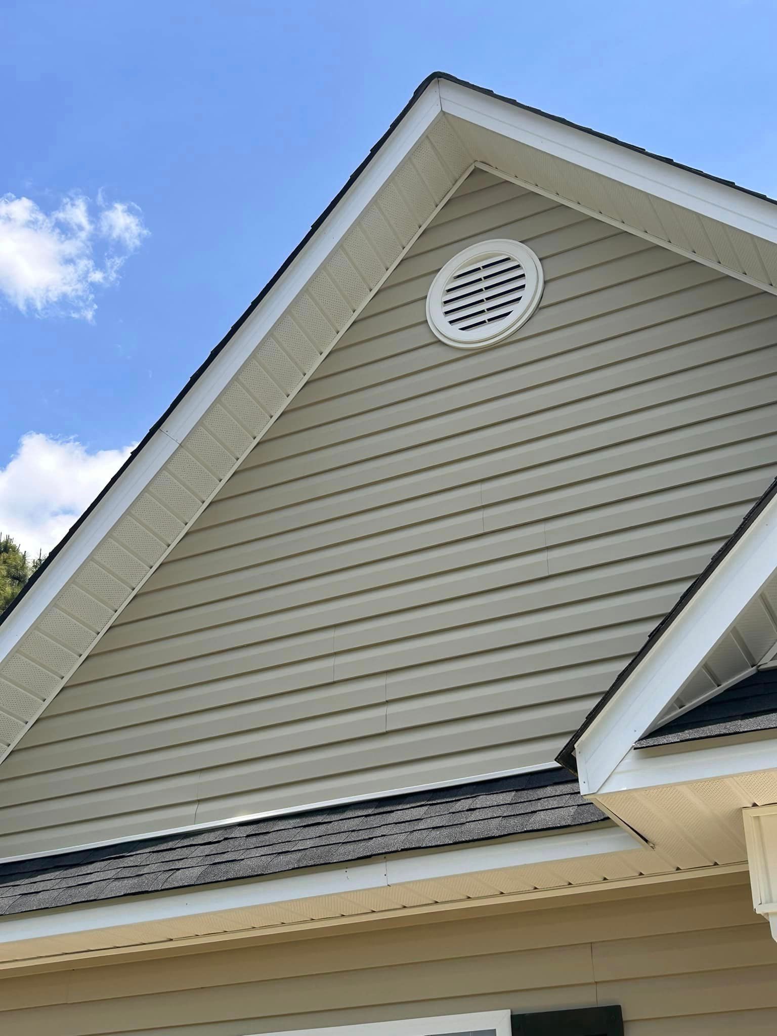The roof of a house has a round vent on it