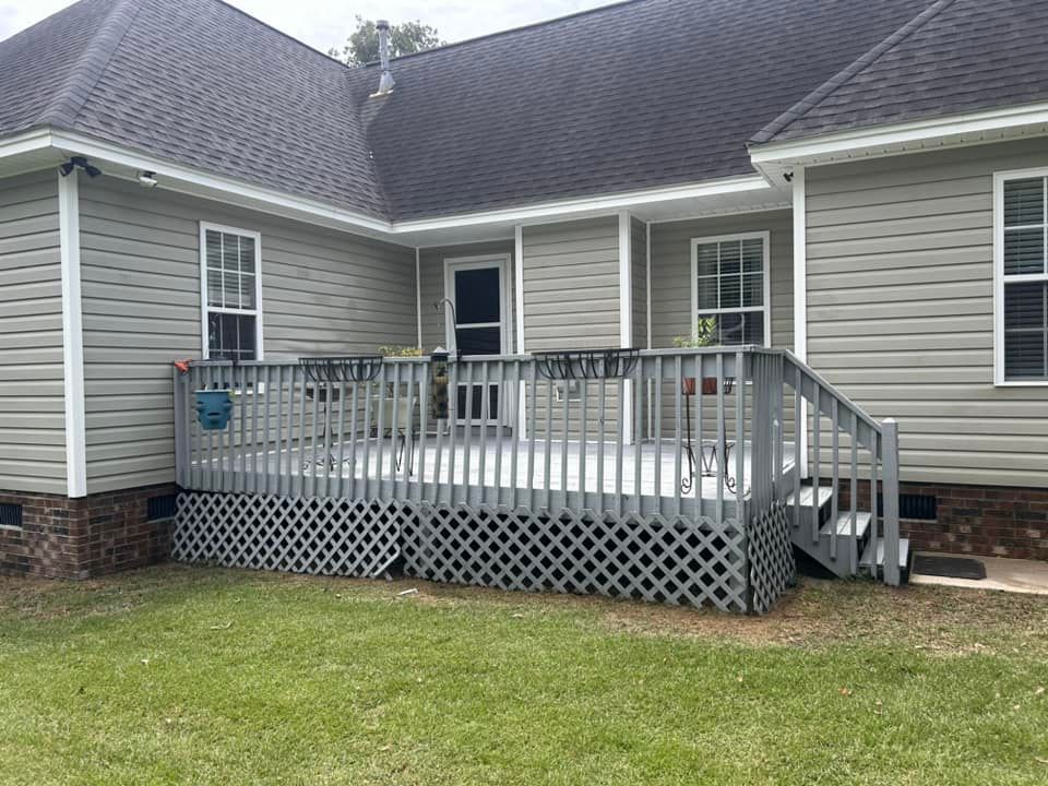 The back of a house with a large deck and stairs.