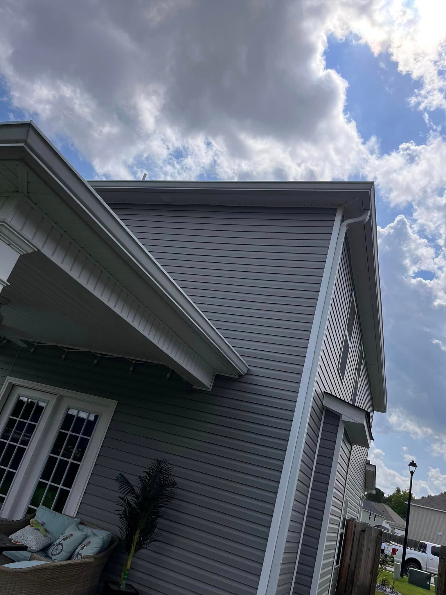 A house with a porch and a blue sky in the background.