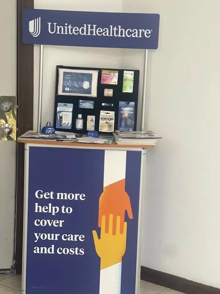 UnitedHealthcare display booth with blue banner and sign reading “Get more help to cover your care and costs.”