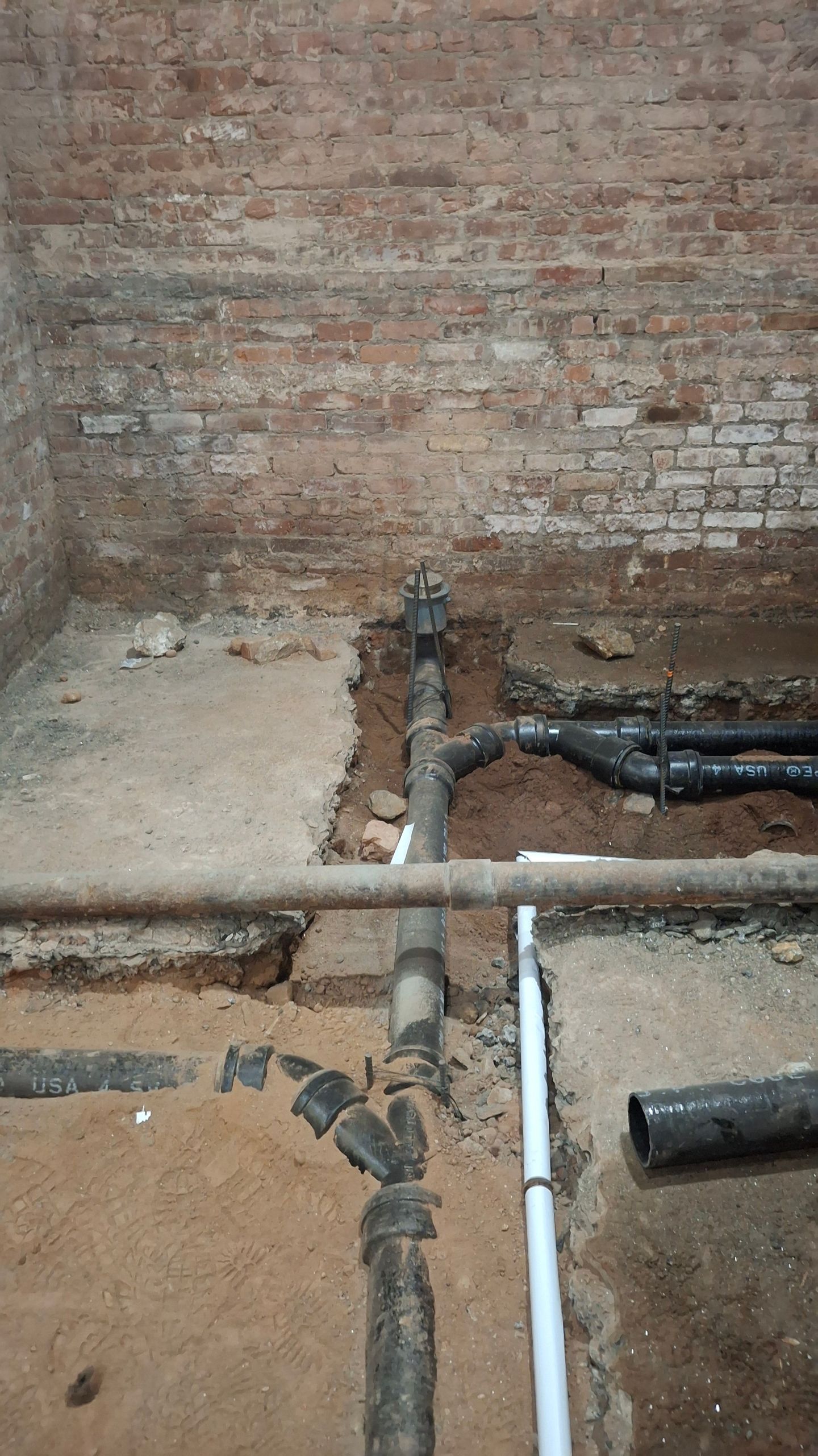 A room with a brick wall and a lot of pipes in it.