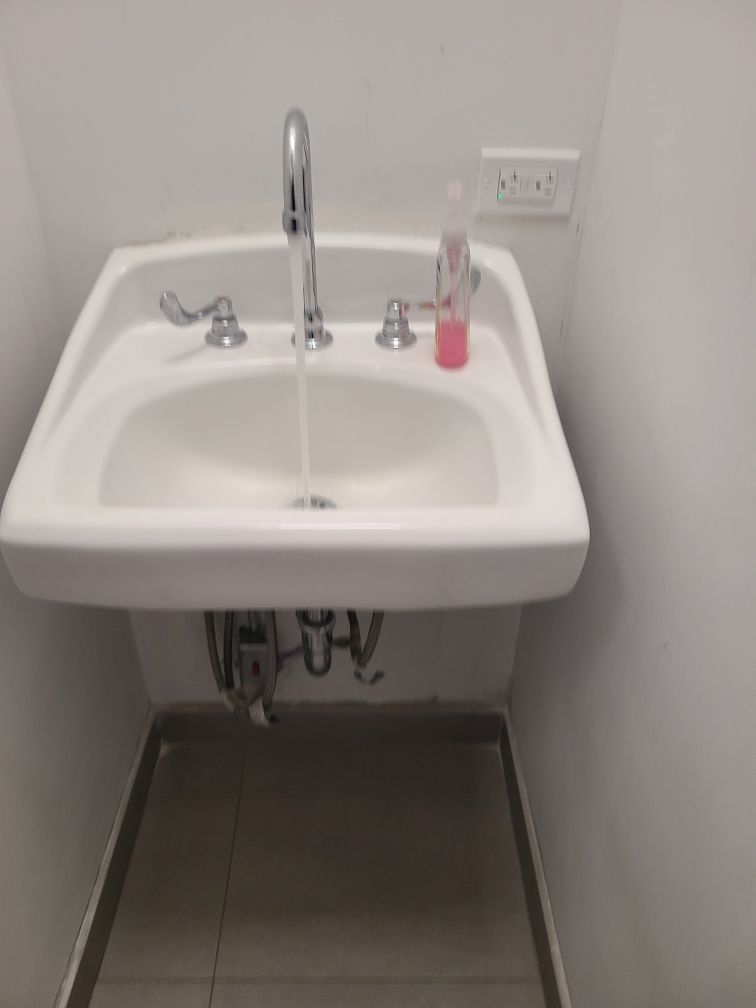 A bathroom sink with water running out of it