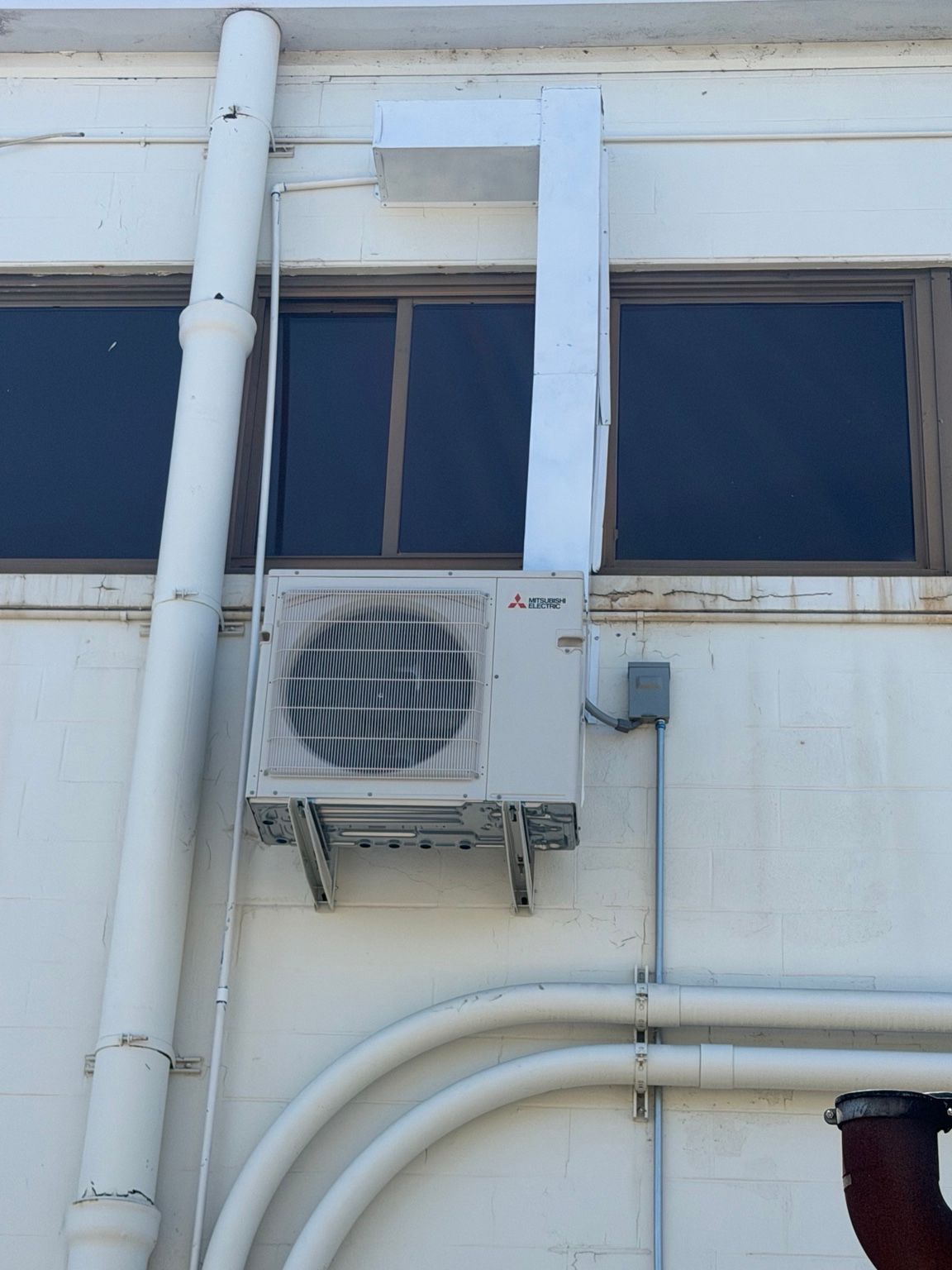 Wall-mounted outdoor HVAC unit and vertical line cover