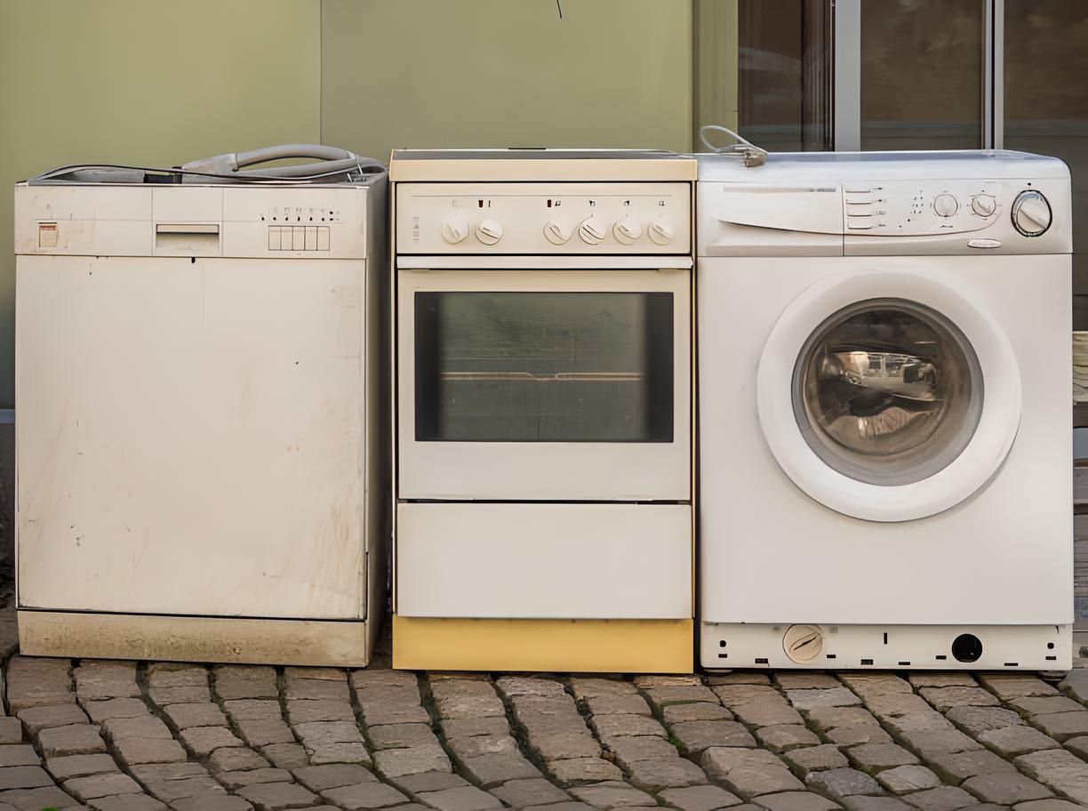 Three white appliances are lined up on a brick sidewalk