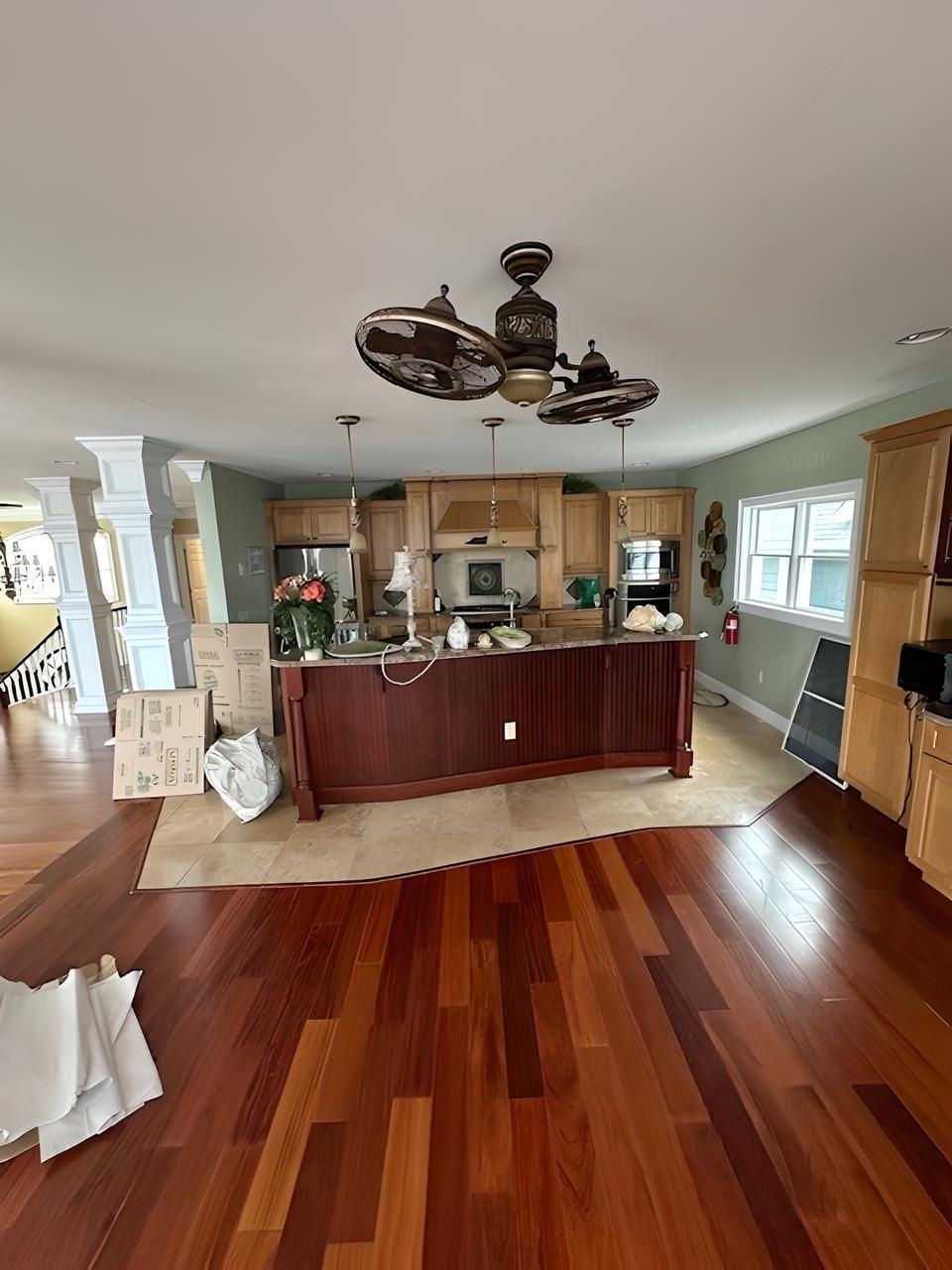 A large kitchen with hardwood floors and a ceiling fan