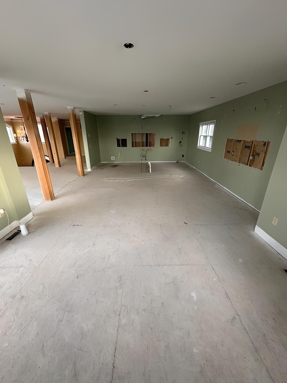 A large empty room with a carpeted floor and green walls