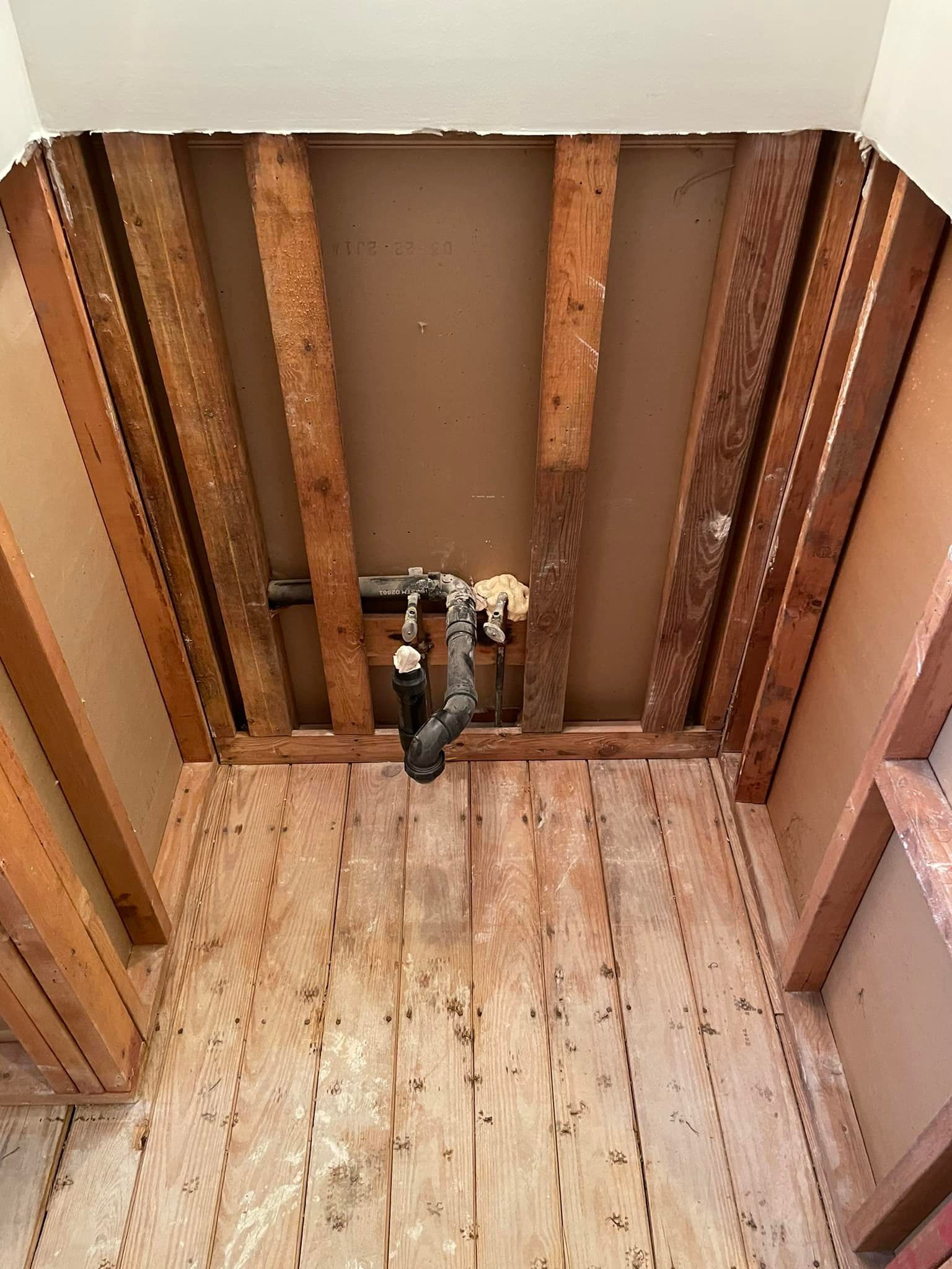 A pipe is hanging from the ceiling of a wooden room