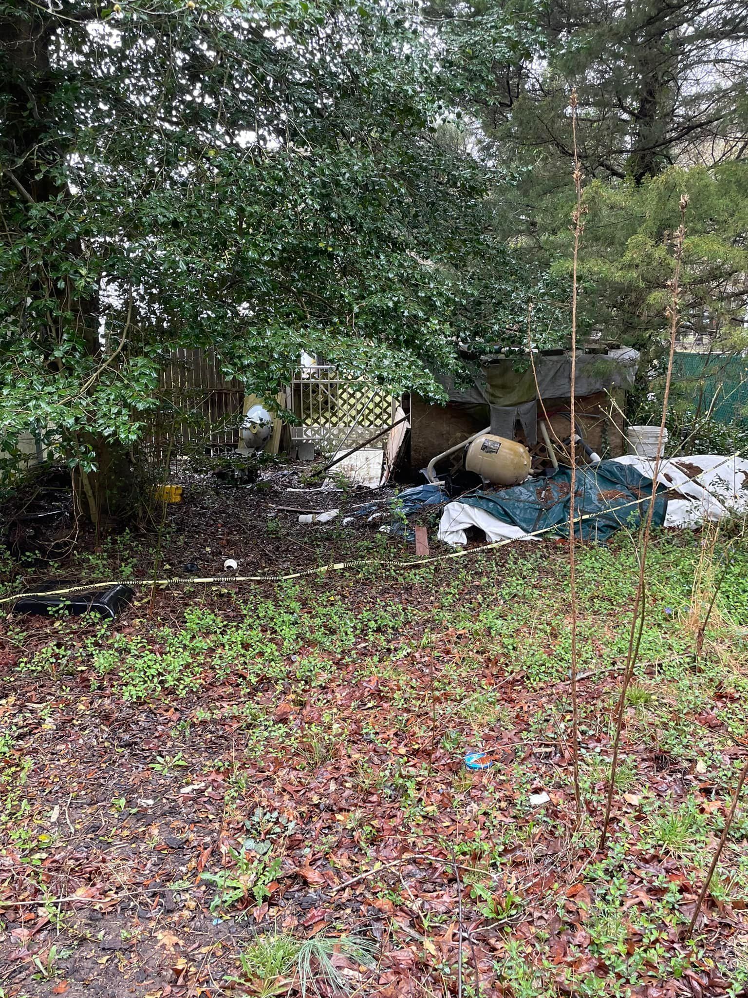 A lot of trash is laying on the ground in a yard