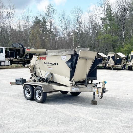 A concrete mixer on a trailer is parked in a parking lot