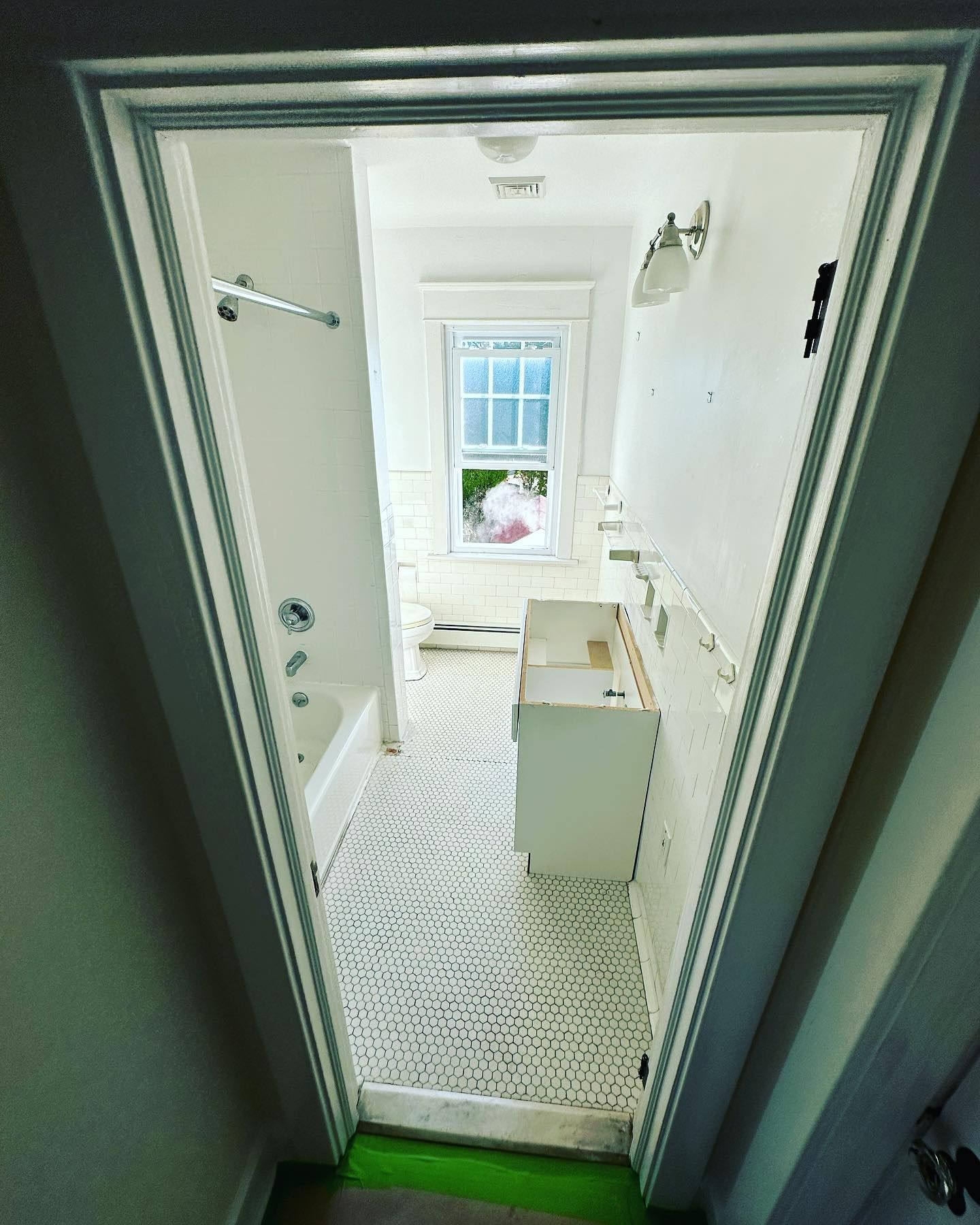 Looking into a bathroom with a window and a sink
