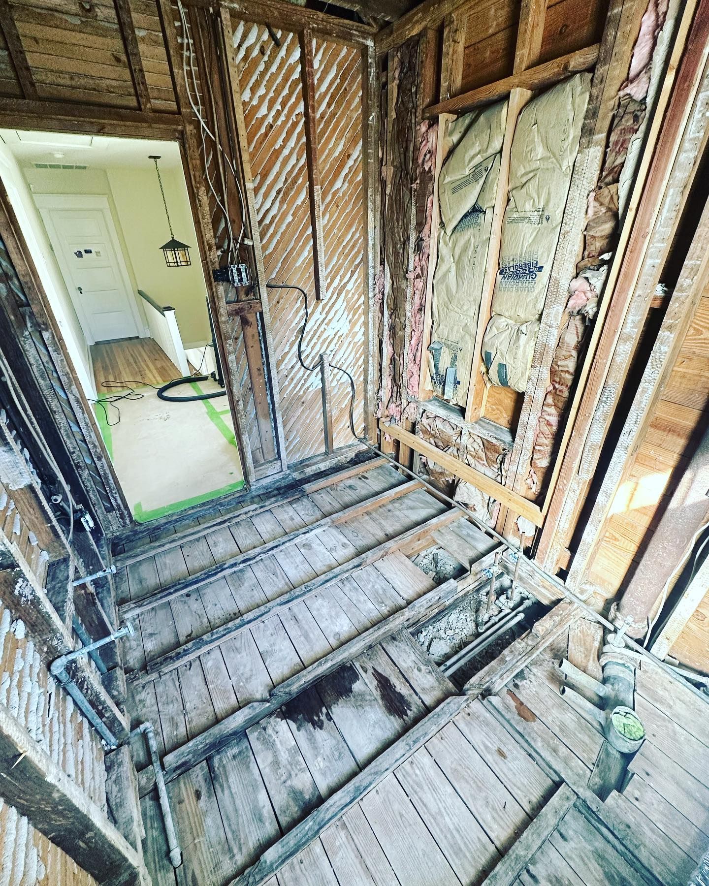 A room with a wooden floor and a door that is being remodeled