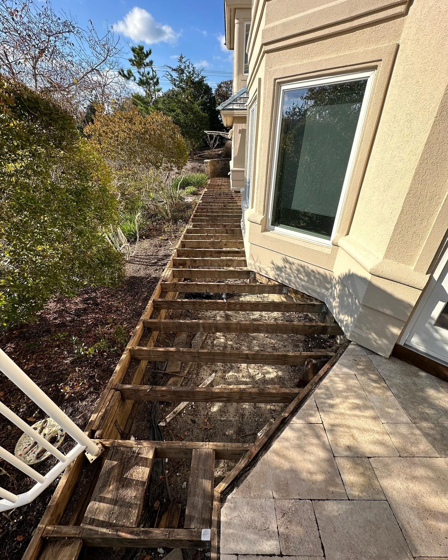 A wooden deck is being built on the side of a house