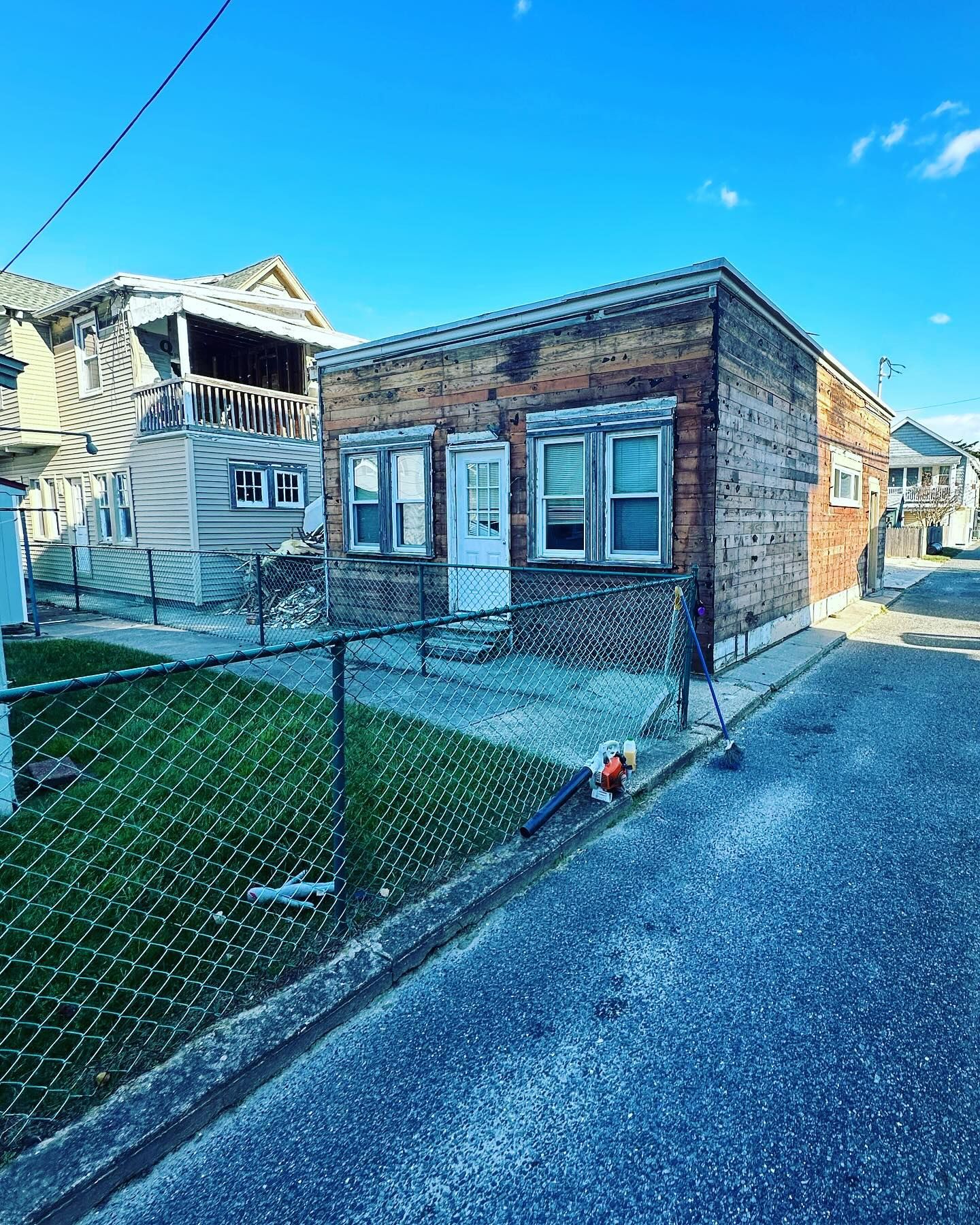 A brick house with a chain link fence in front of it