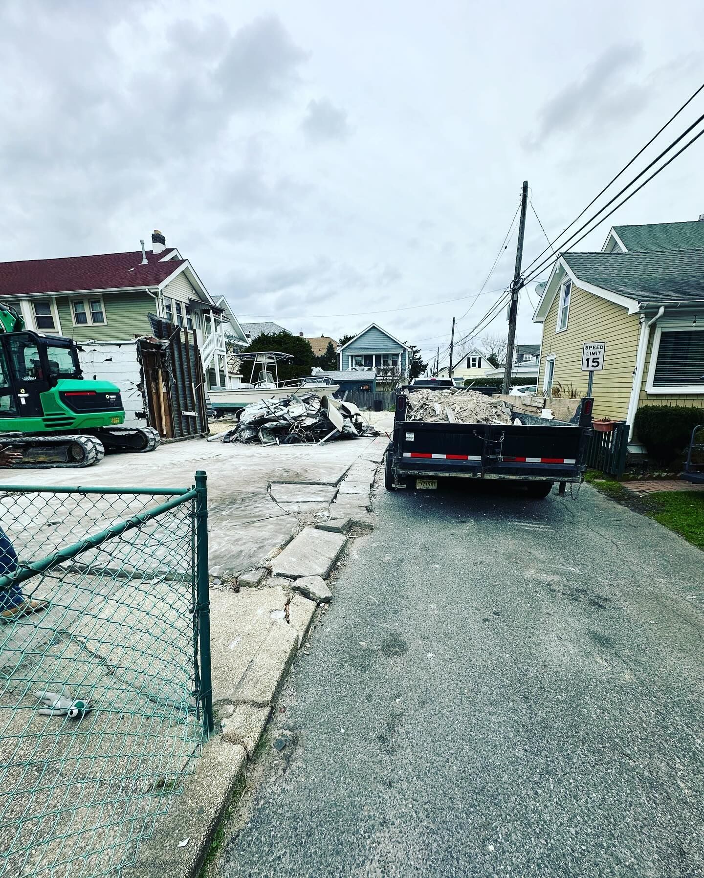 A trailer is sitting on the side of the road next to a house