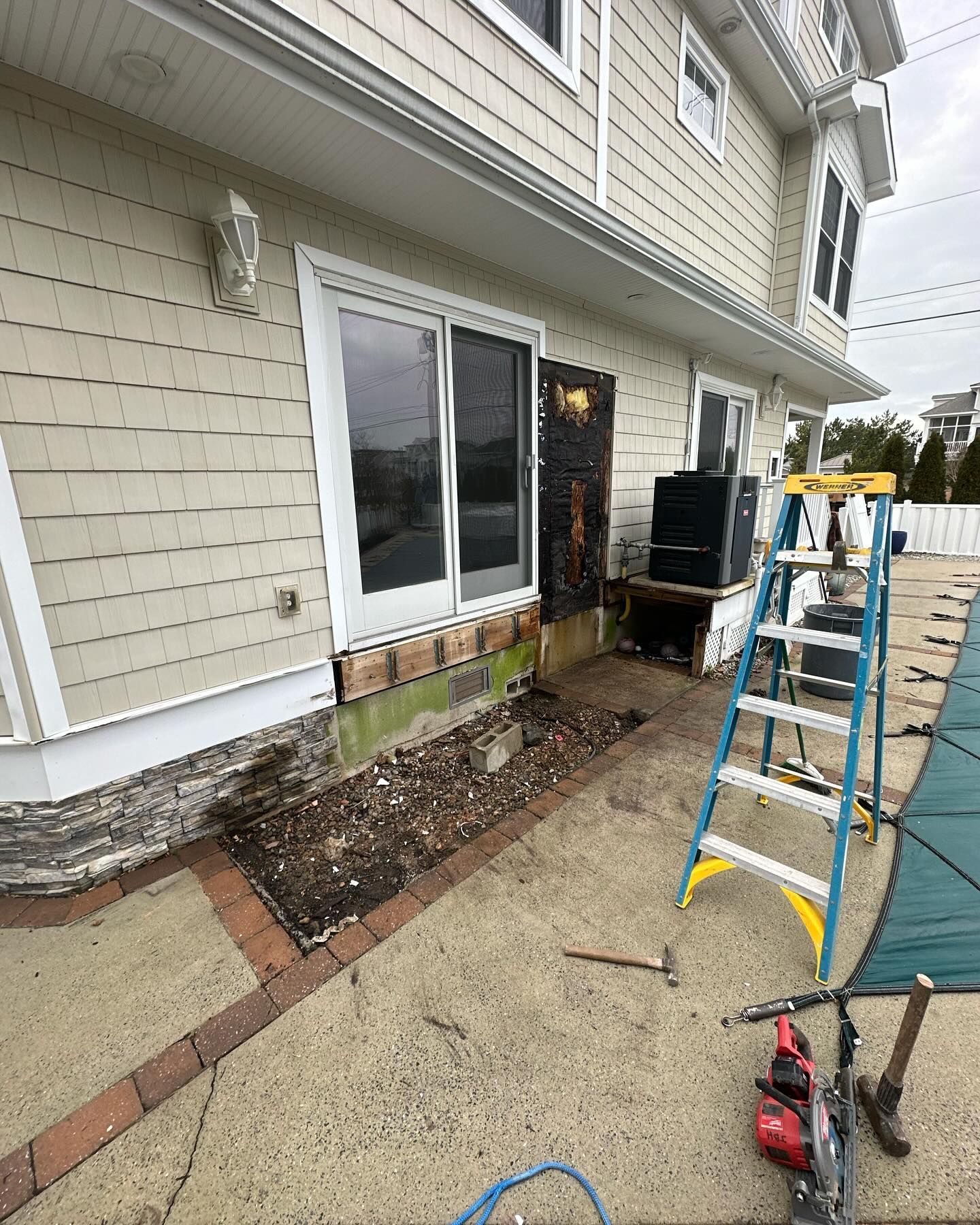 A ladder is sitting in front of a house that is being remodeled
