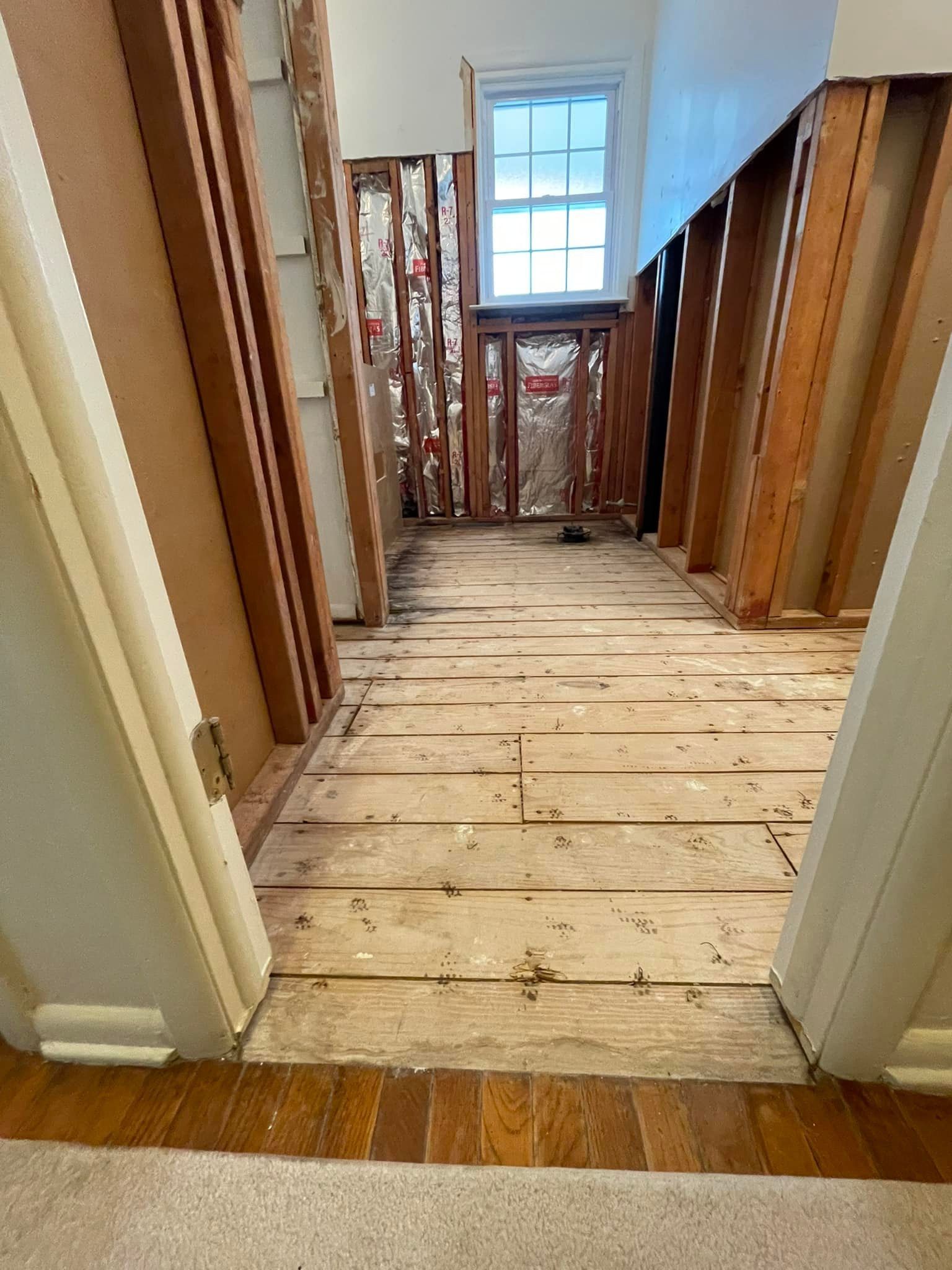 A hallway with a wooden floor and a window
