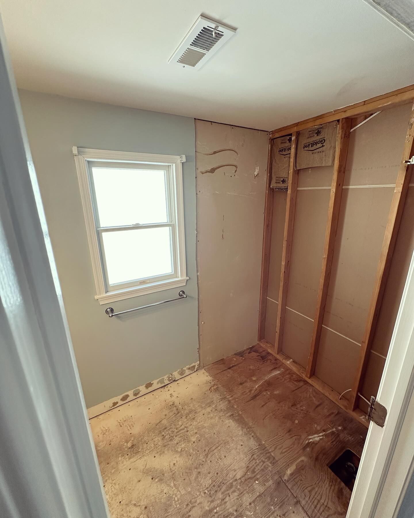 An empty room with a window and a ceiling fan