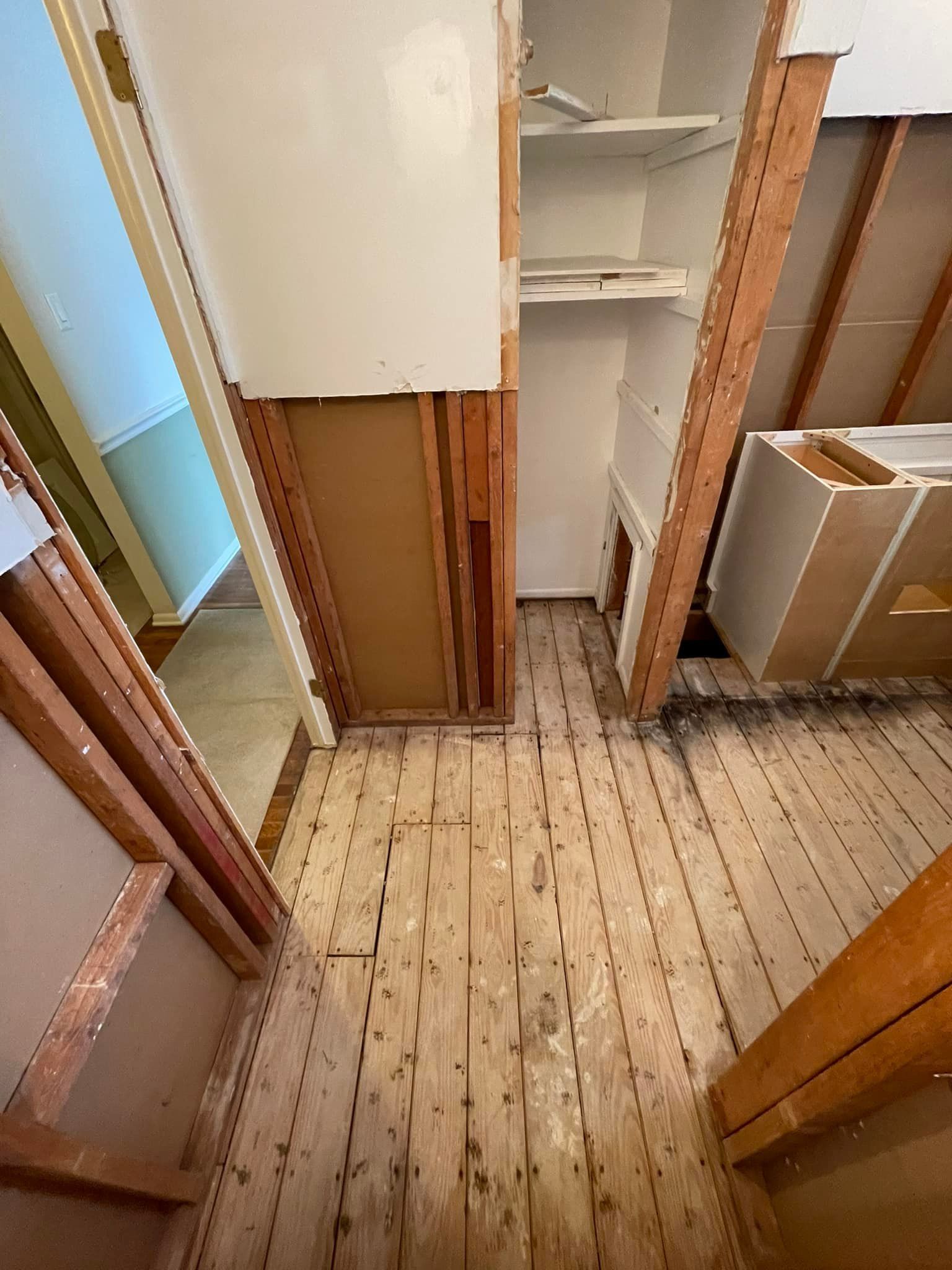 A closet with a wooden floor and a white cabinet