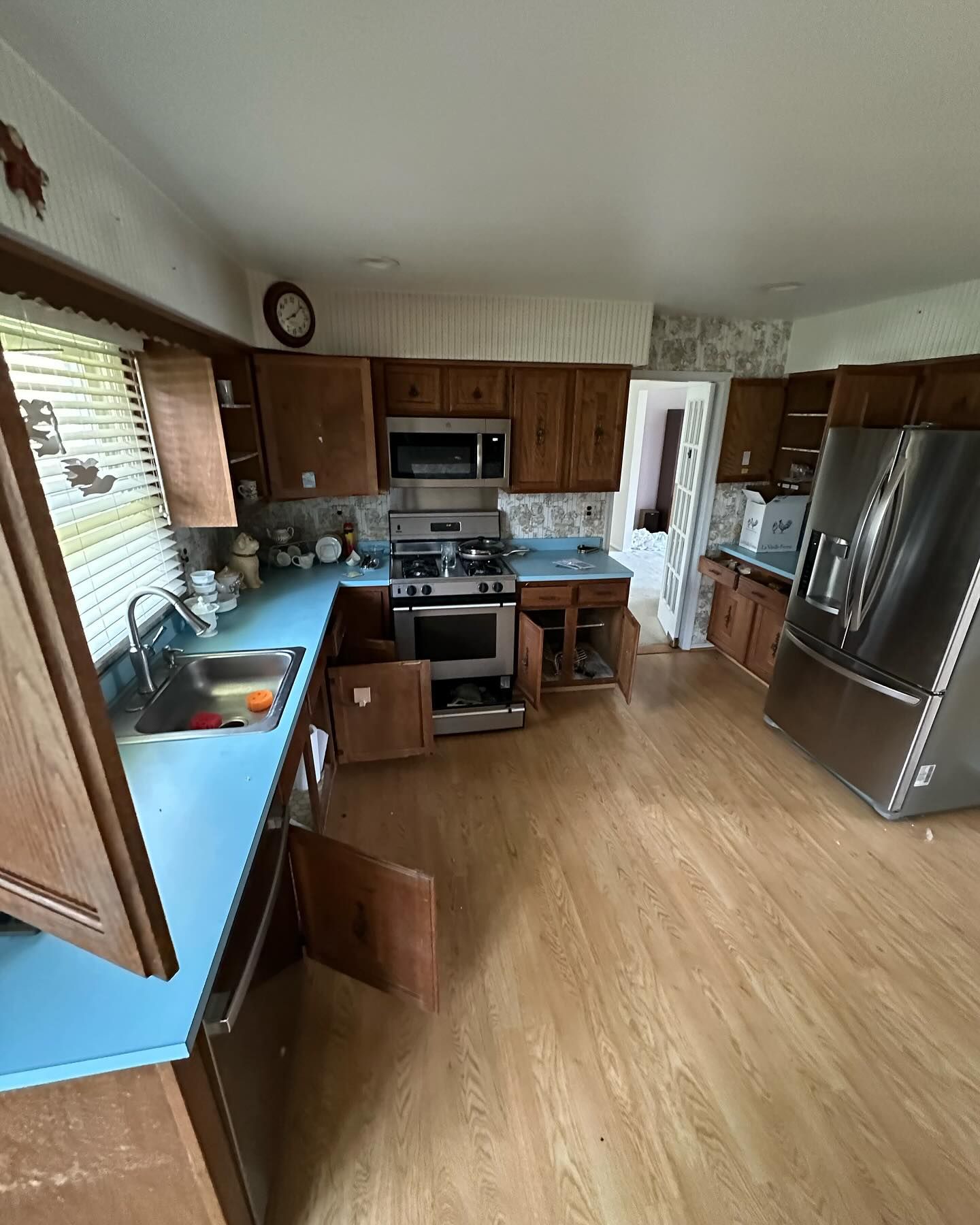 A kitchen with stainless steel appliances and blue counter tops