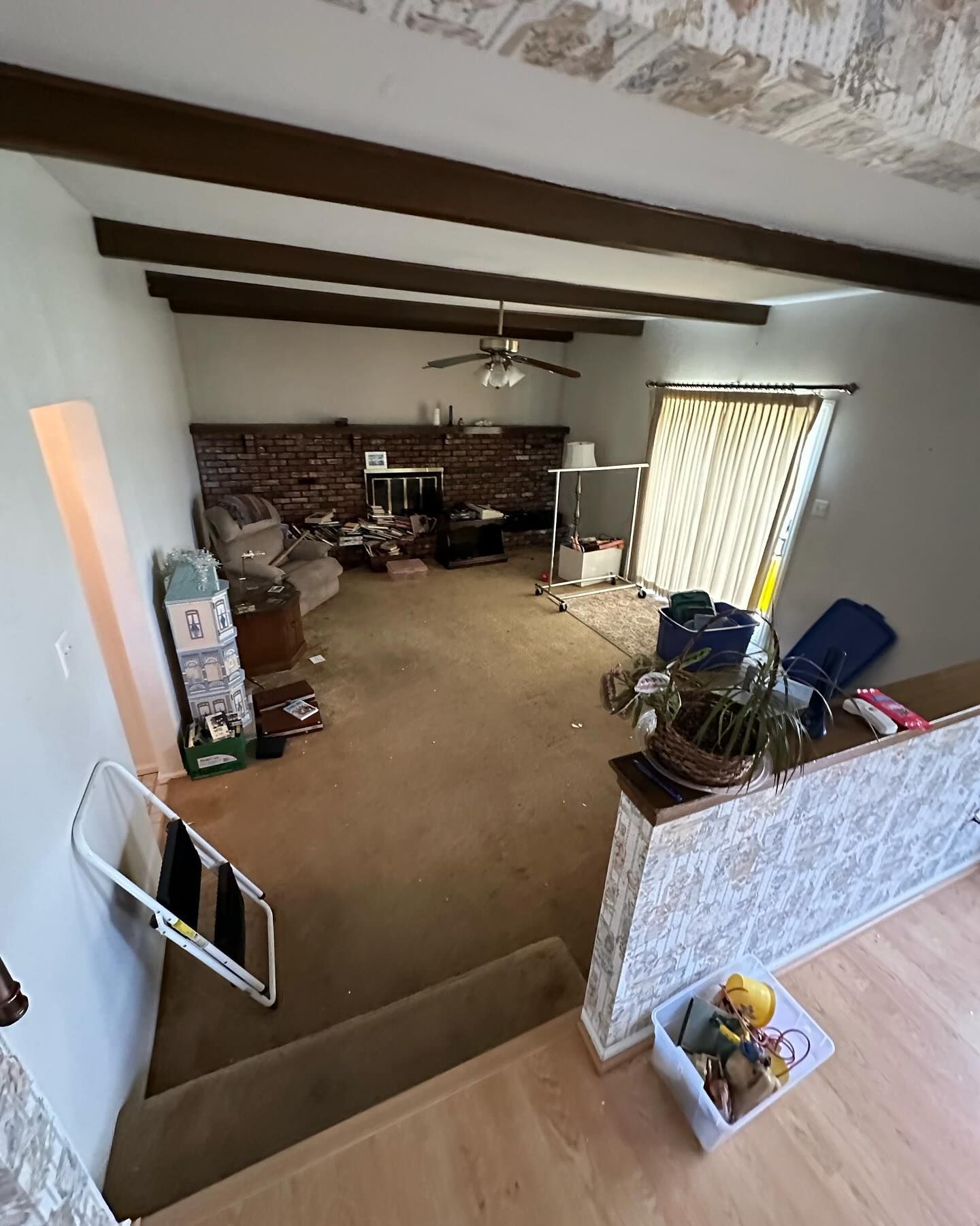 A living room with a ceiling fan and a brick wall