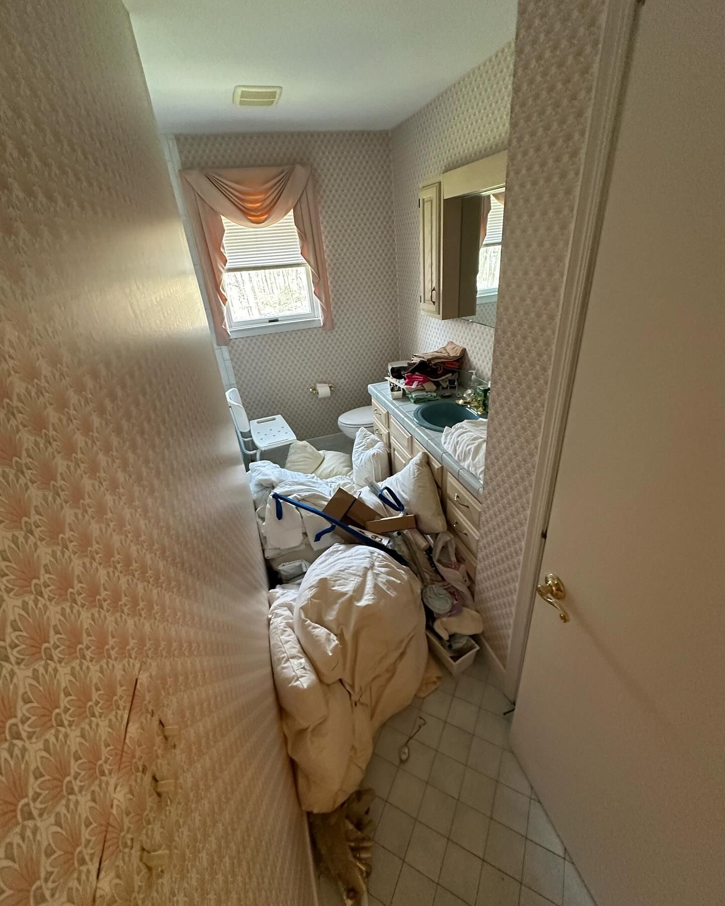 A bathroom with a lot of stuff on the floor