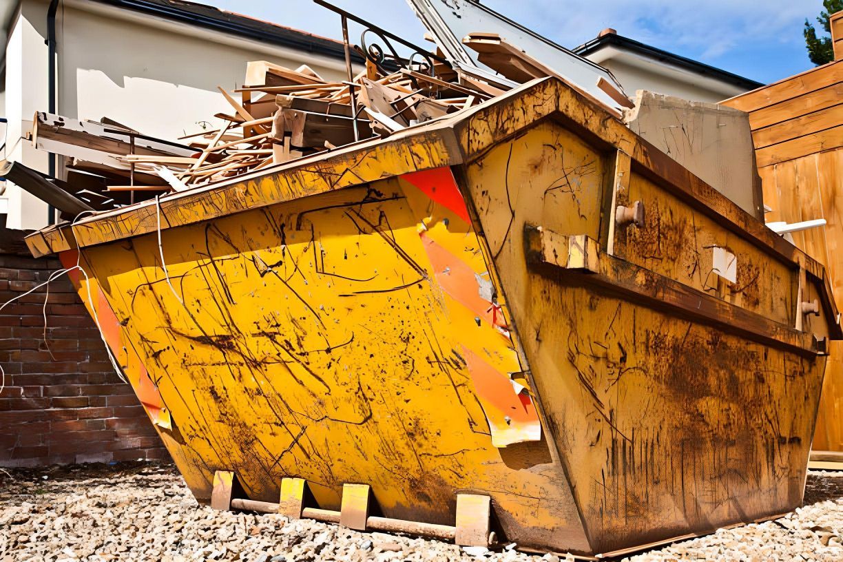 A yellow dumpster with a red sticker that says recycling on it