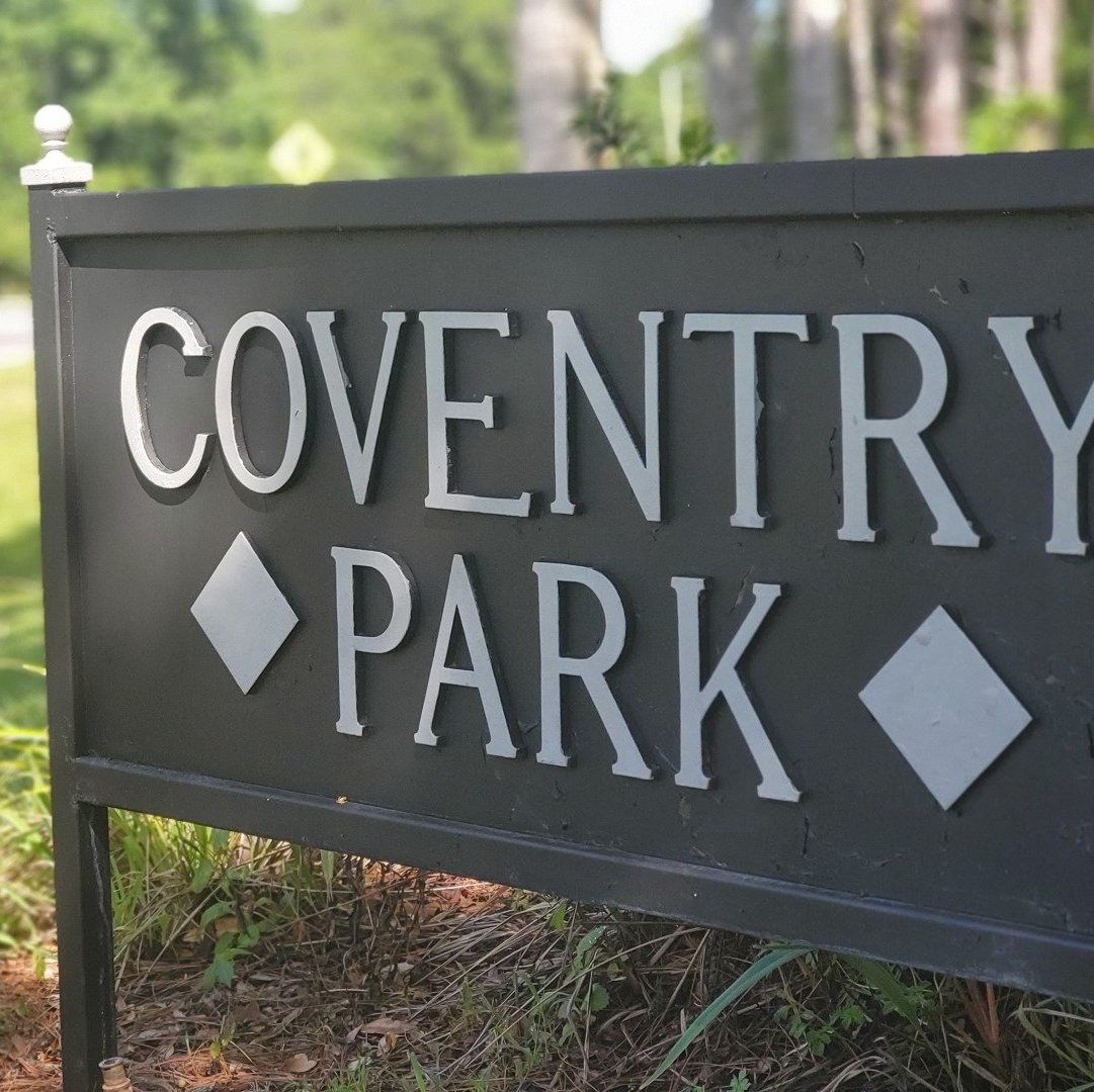 A black sign that says coventry park on it