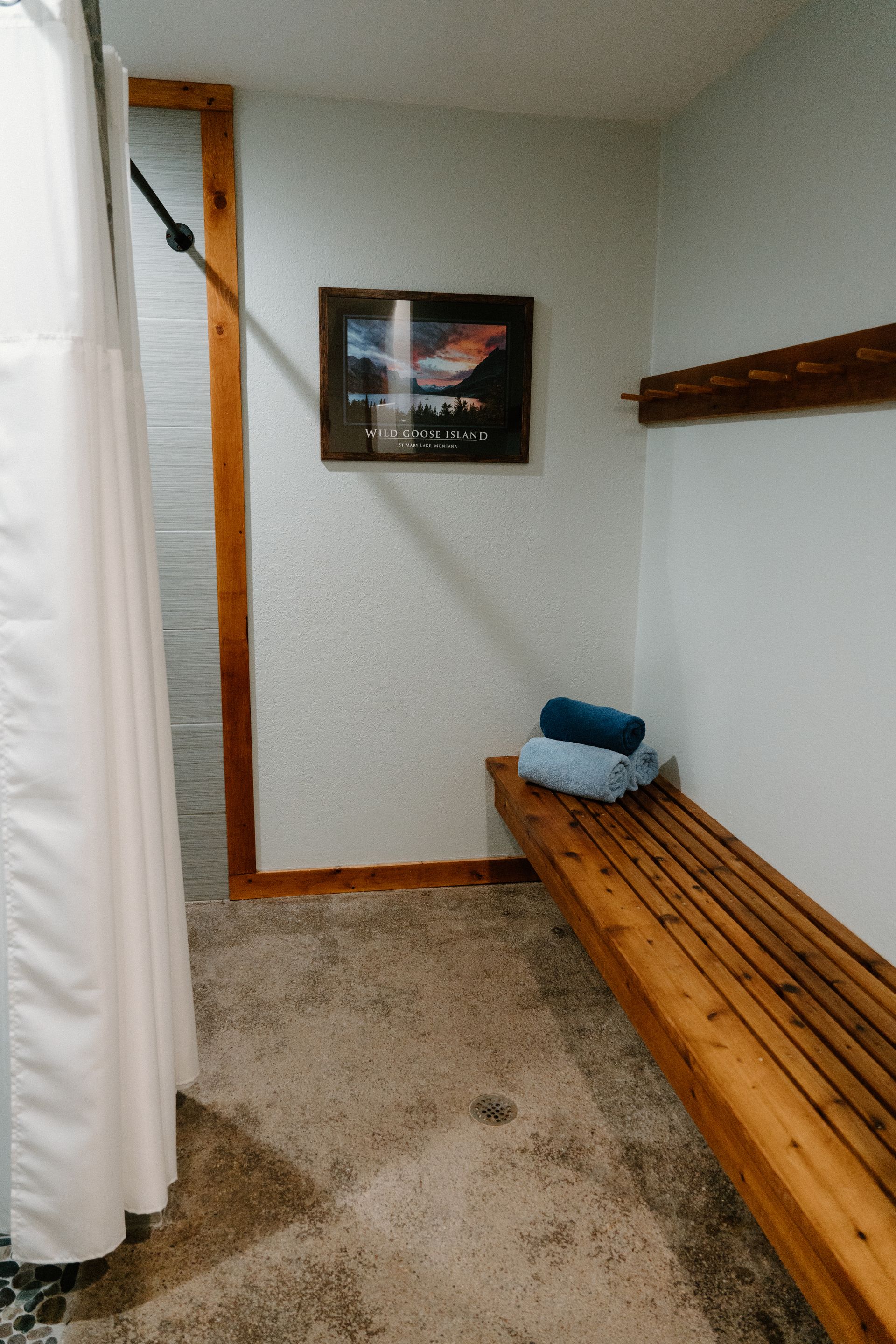 A bathroom with a wooden bench and a shower curtain.