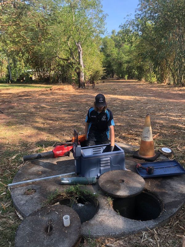 A Man is Cleaning A Grease Trap In A Field — Fastcall Group In Herbert, NT