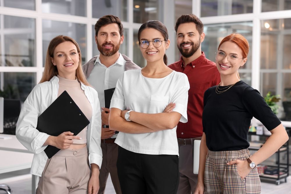 Un grupo de personas posa para una fotografía en una oficina.