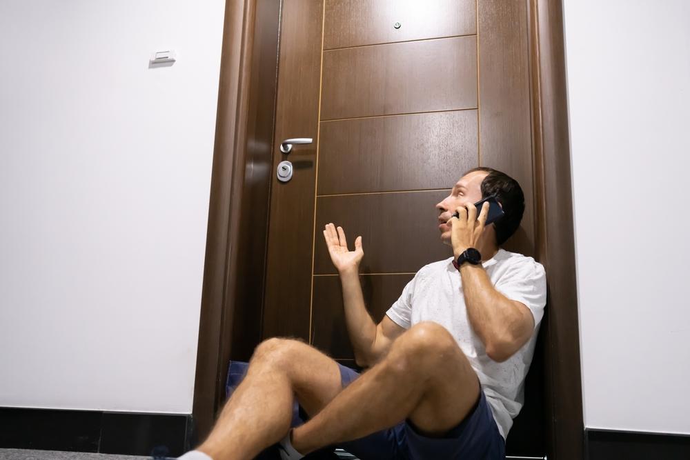 Man Sitting In Front of Locked Door — Locksmith in Annandale, QLD