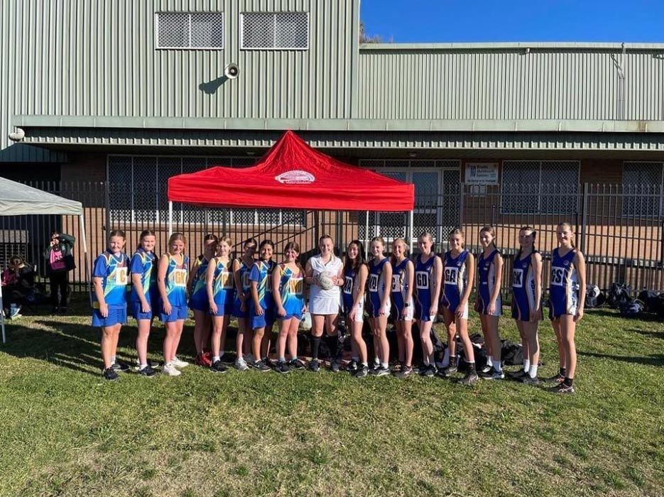 Group Of Women Wearing Printed Sports Attire With Red Tent At The Back — Promotional Apparel In Kiama, NSW