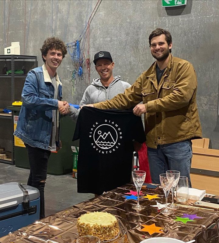 Man Holding The Printed Promotional Black Shirt — Promotional Apparel In Woonona, NSW