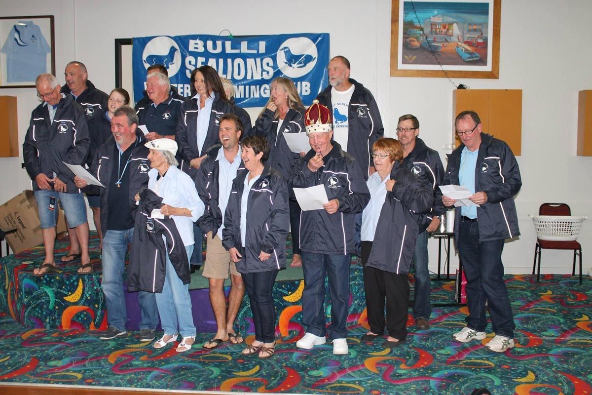 Set Of People Smiling While Holding Paper Wearing Custom Made Jackets — Promotional Apparel In Woonona, NSW