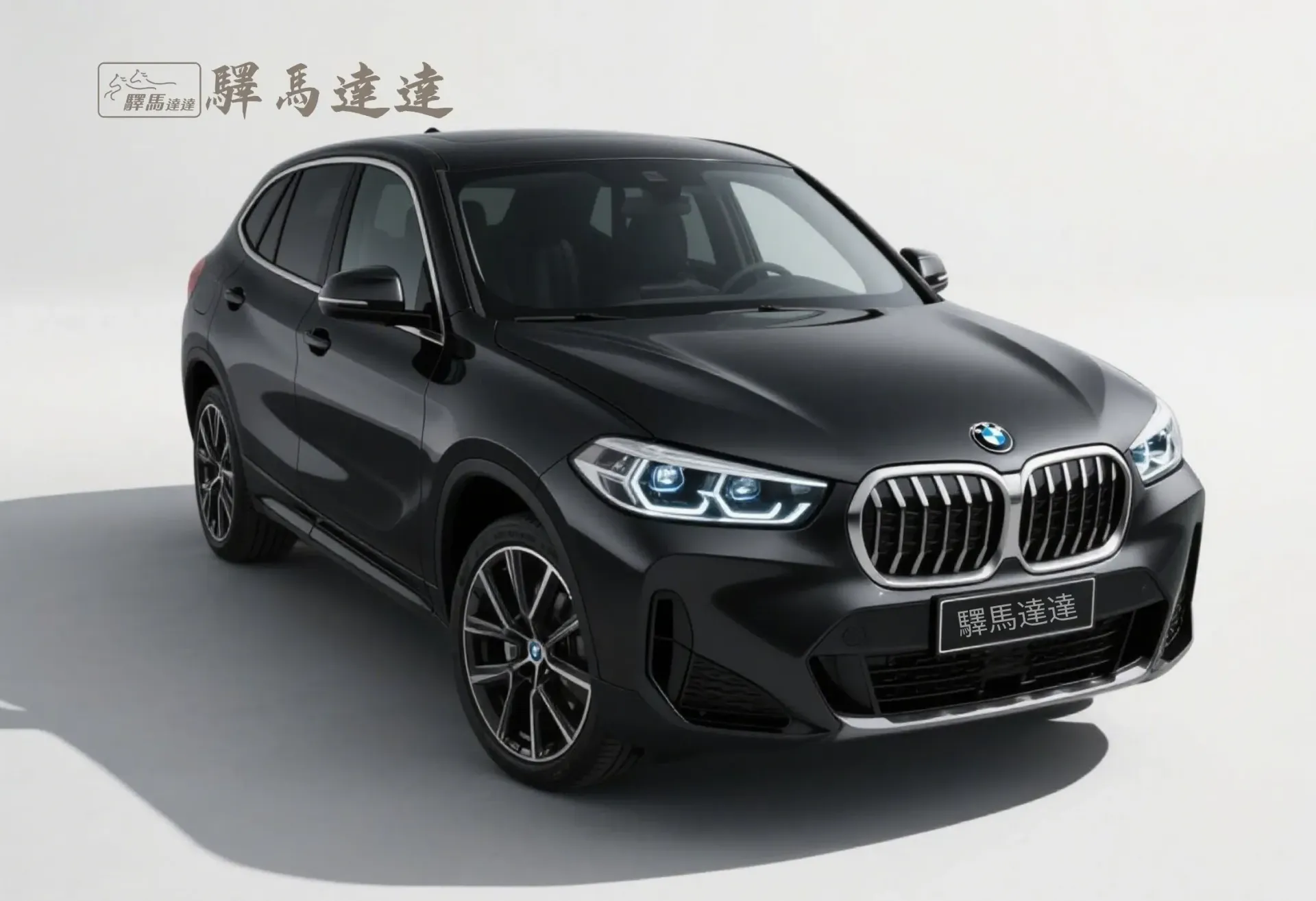 前方45度視角的寶馬iX1黑色車輛，完整展現外觀設計，包括車頭燈、品牌logo流線型車身線條。畫面左上角顯示「驛馬達達」標誌。