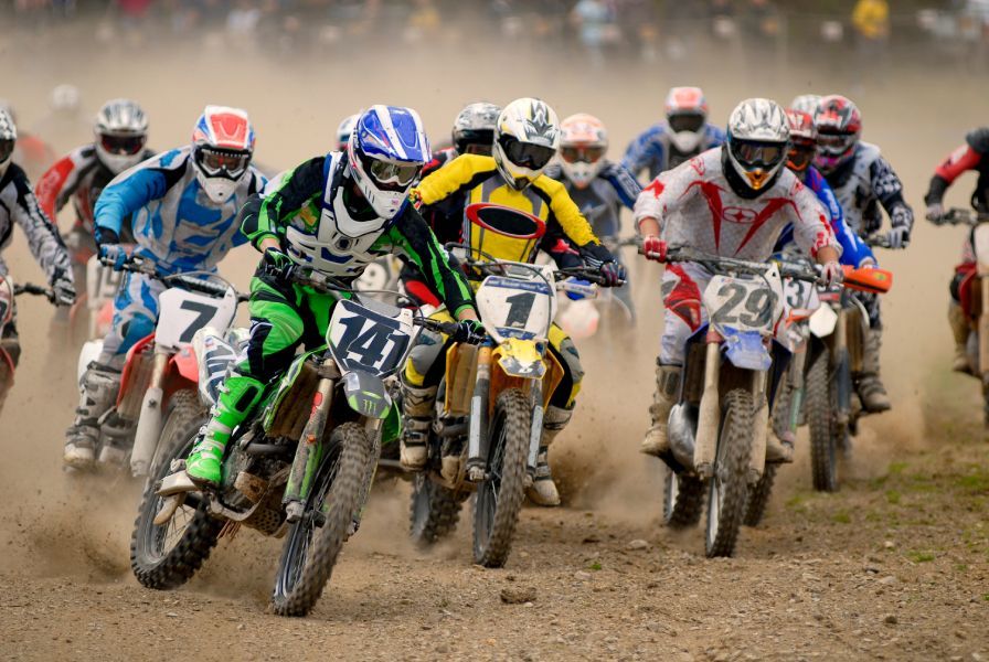 A group of people are riding dirt bikes on a dirt track.