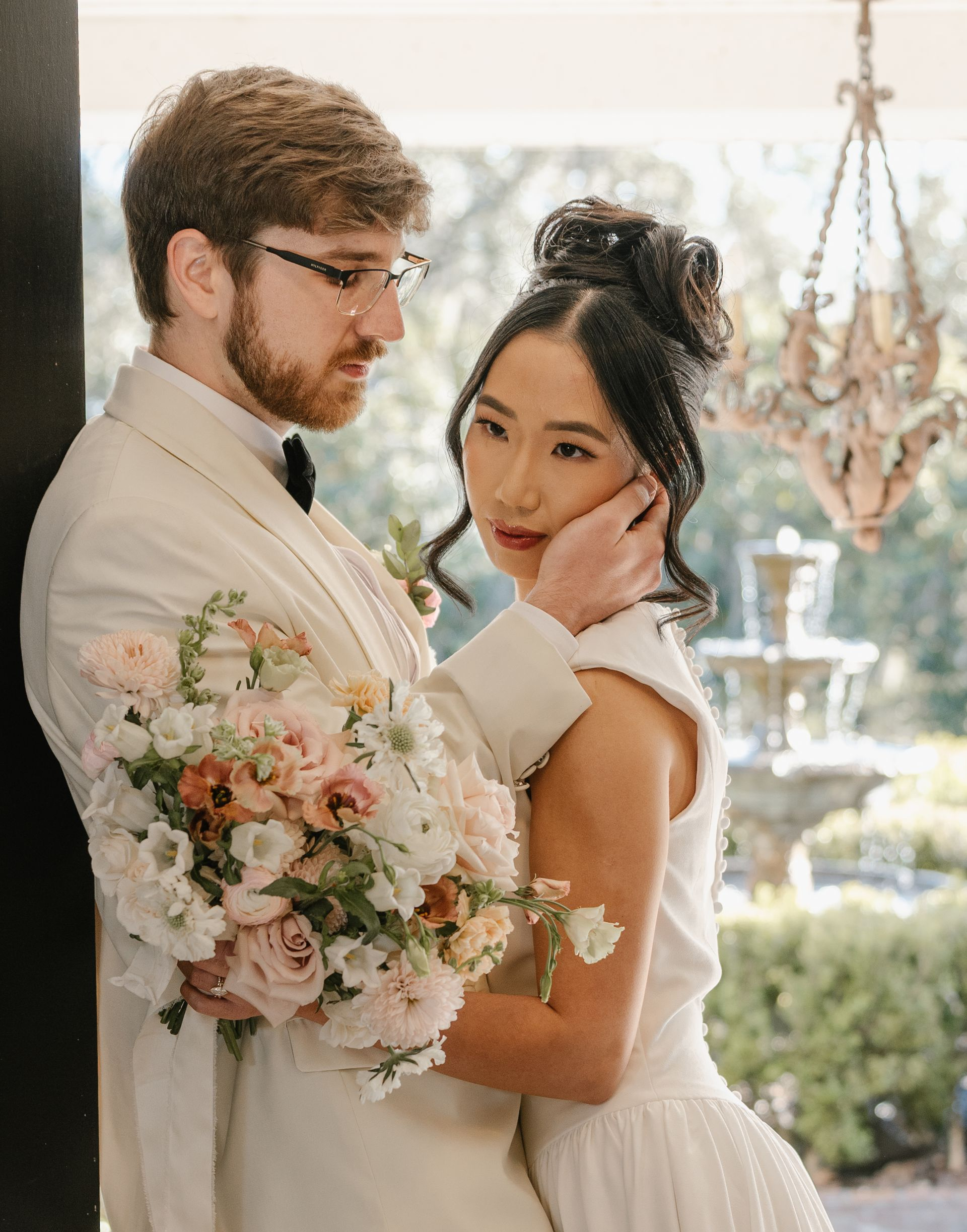 bride and groom with bridal bouquet and fountain in the background