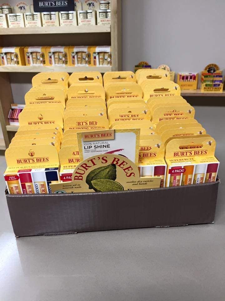 Display of Burt's Bees lip balm in a brown store bin. Yellow packaging and logo are visible.