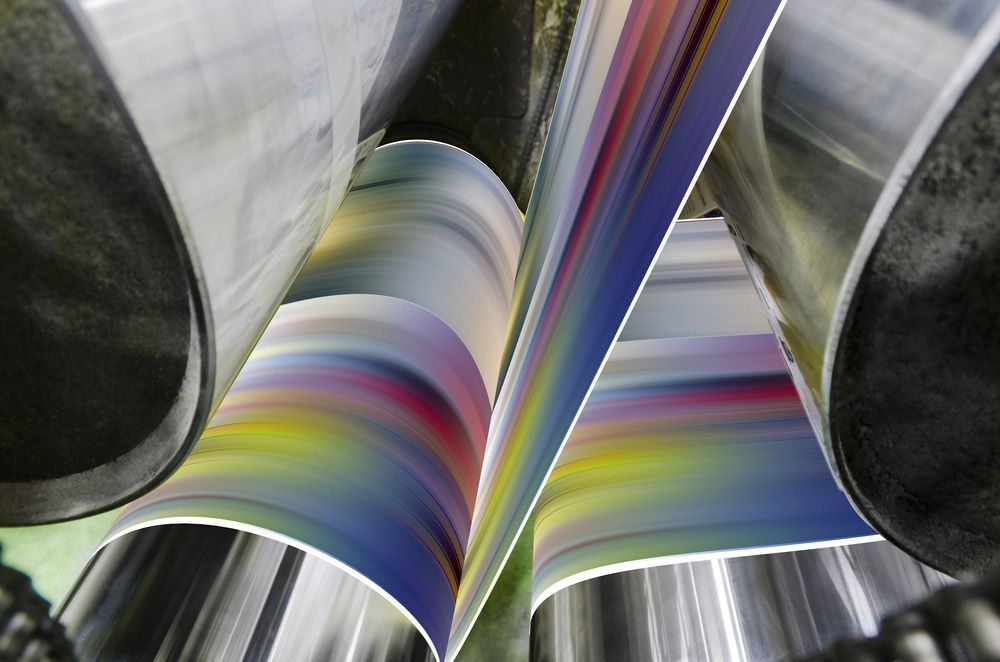 Printing Machine Running A Long Roll Off Paper Over It's Rollers — Graphic Designer In Airlie Beach, QLD