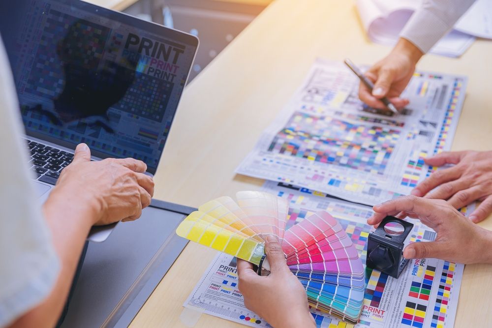 Worker Checking The Print Quality Using Magnifying Glass — Graphic Designer In Nowra, QLD