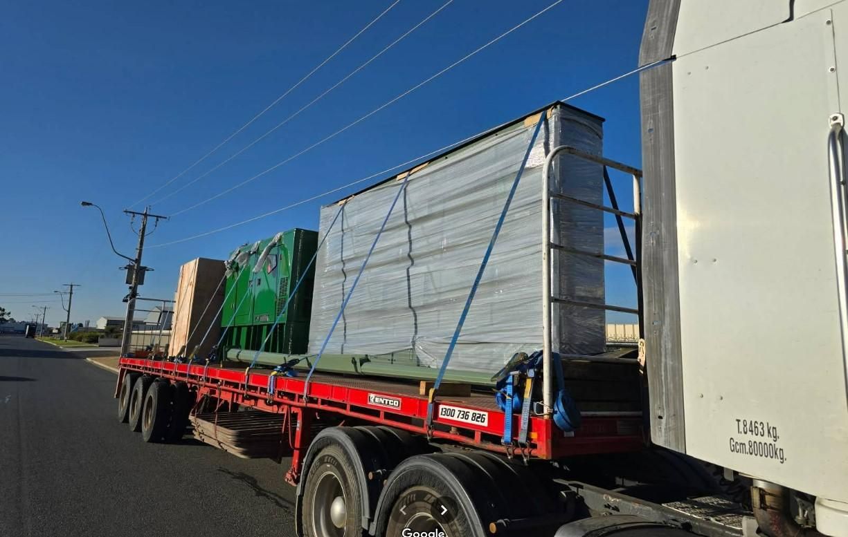 A Semi Truck is Driving Down a Road With Boxes on the Back of It — Goulburn Transport In Canberra, ACT