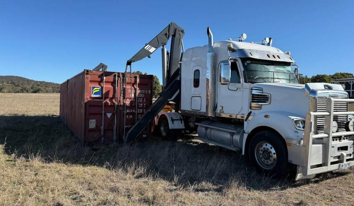 A white truck is picking up a carton — Goulburn Transport In Adelaide, SA