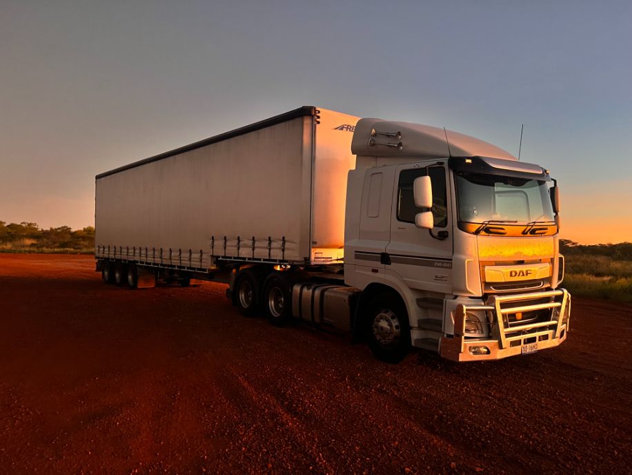 A White Semi Truck is Parked on a Dirt Road — Goulburn Transport In Sydney, NSW