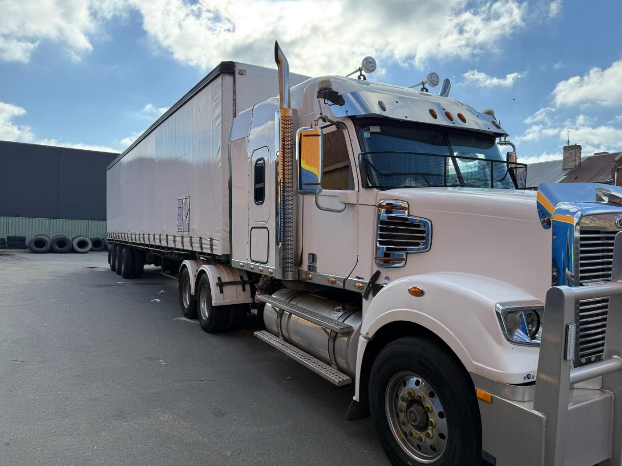 A White Semi Truck With a Trailer is Parked in a Parking Lot — Goulburn Transport In Melbourne, VIC