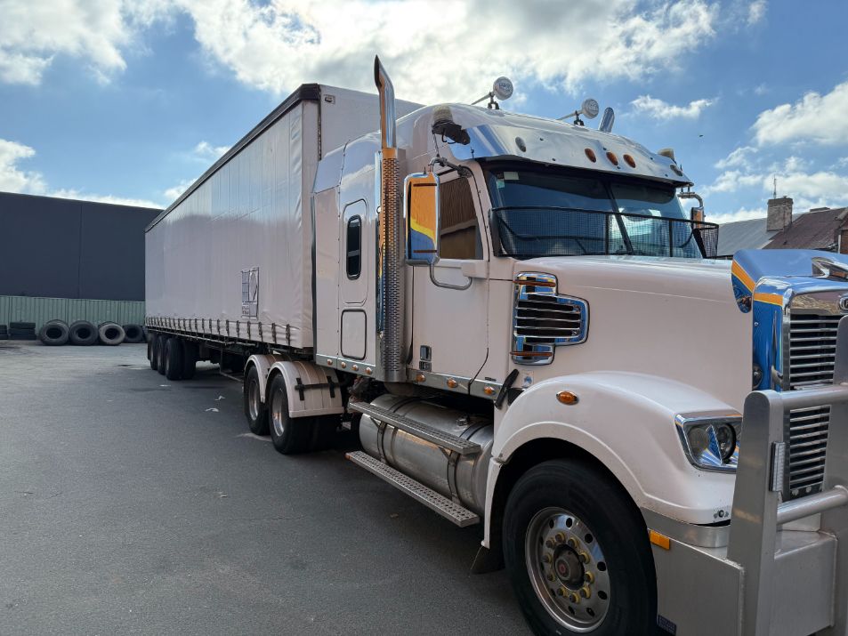 A White Semi Truck With a Trailer Attached to It is Parked — Goulburn Transport In Goulburn, NSW