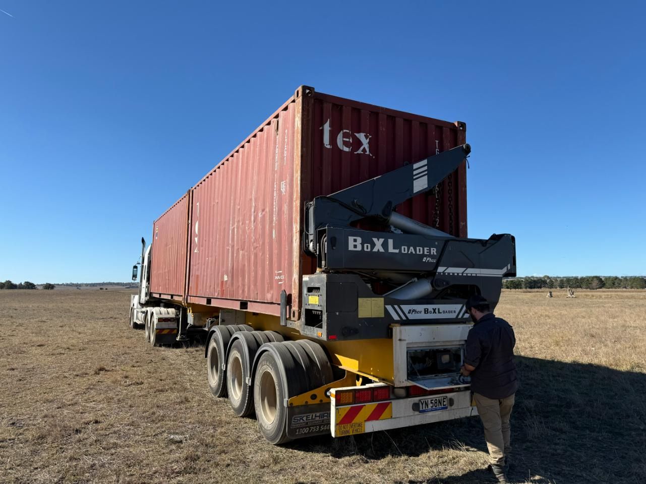 A Man is Standing Next to a Truck — Goulburn Transport In Melbourne, VIC