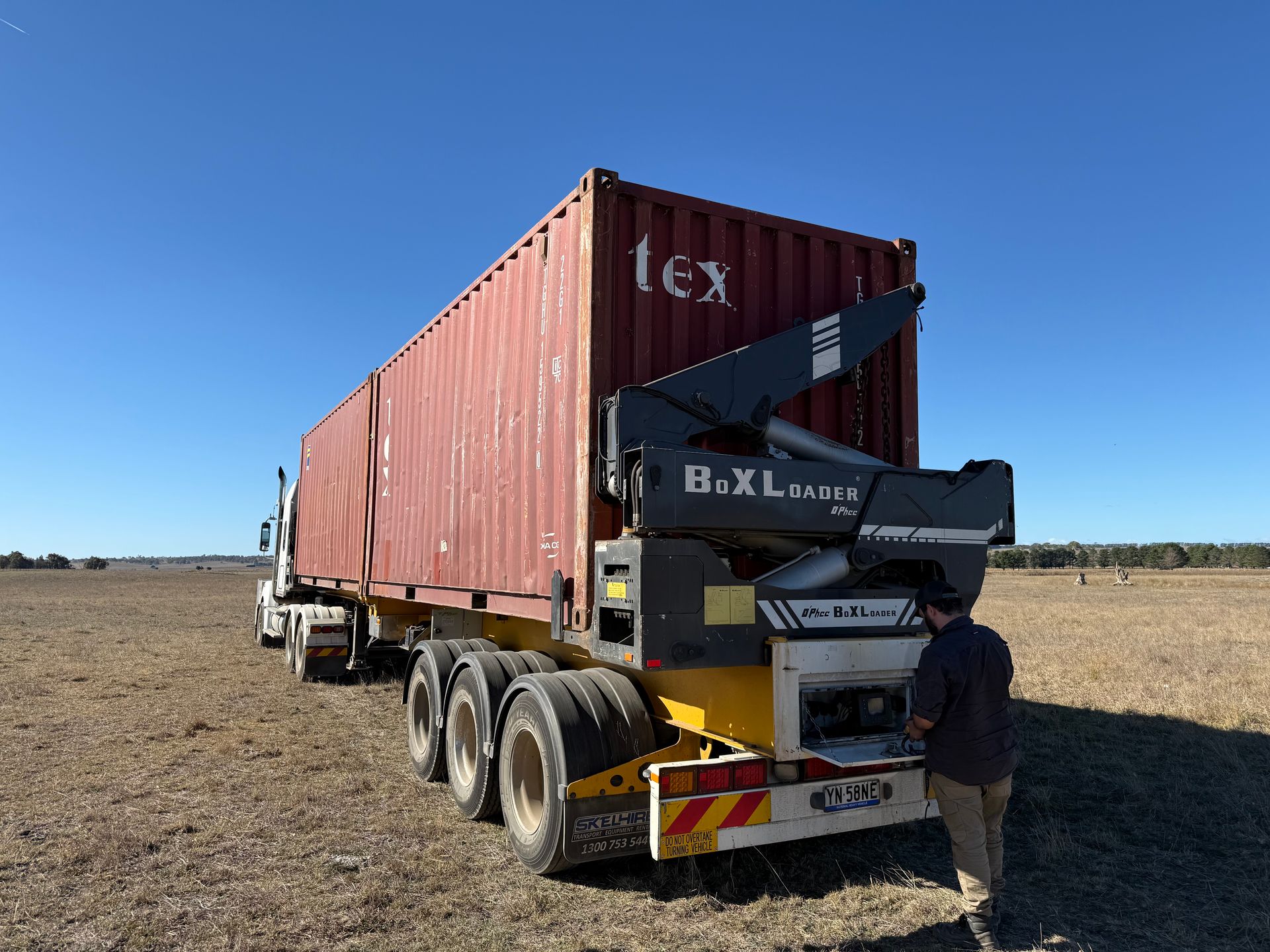 A Large Truck Is Parked In A Field And A Man Is Standing Behind It— Goulburn Transport In Goulburn, NSW