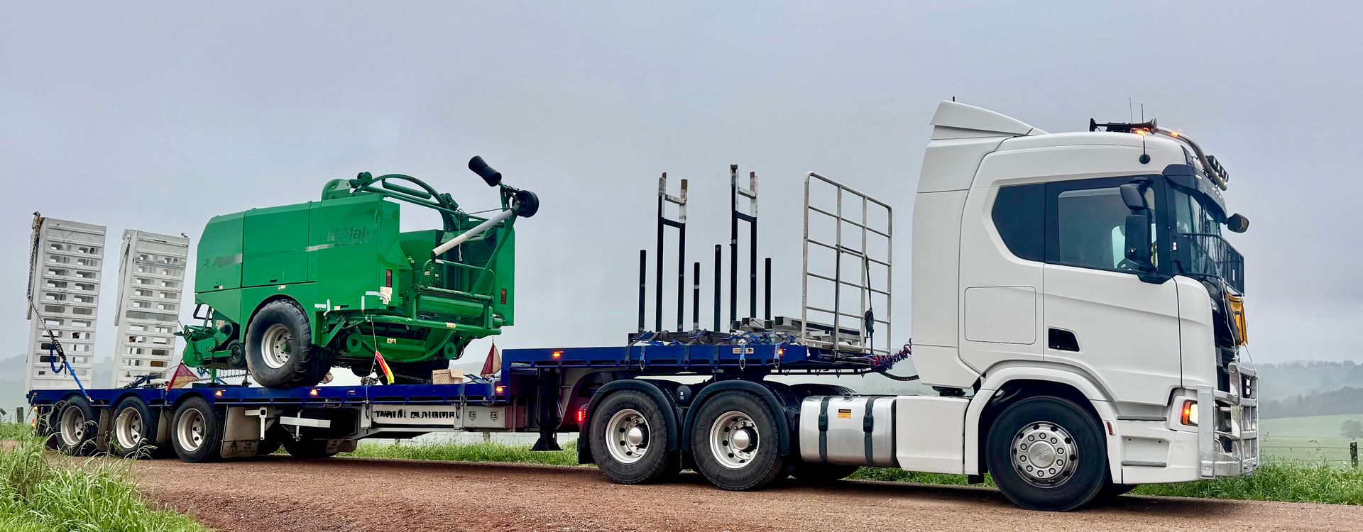 a truck with a green machine on the back — Goulburn Transport In Melbourne, VIC