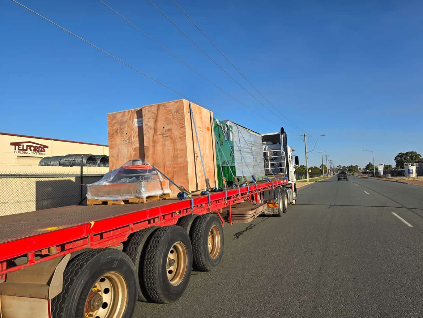 A Semi Truck is Driving Down a Road With Boxes on the Back of It — Goulburn Transport In Goulburn, NSW