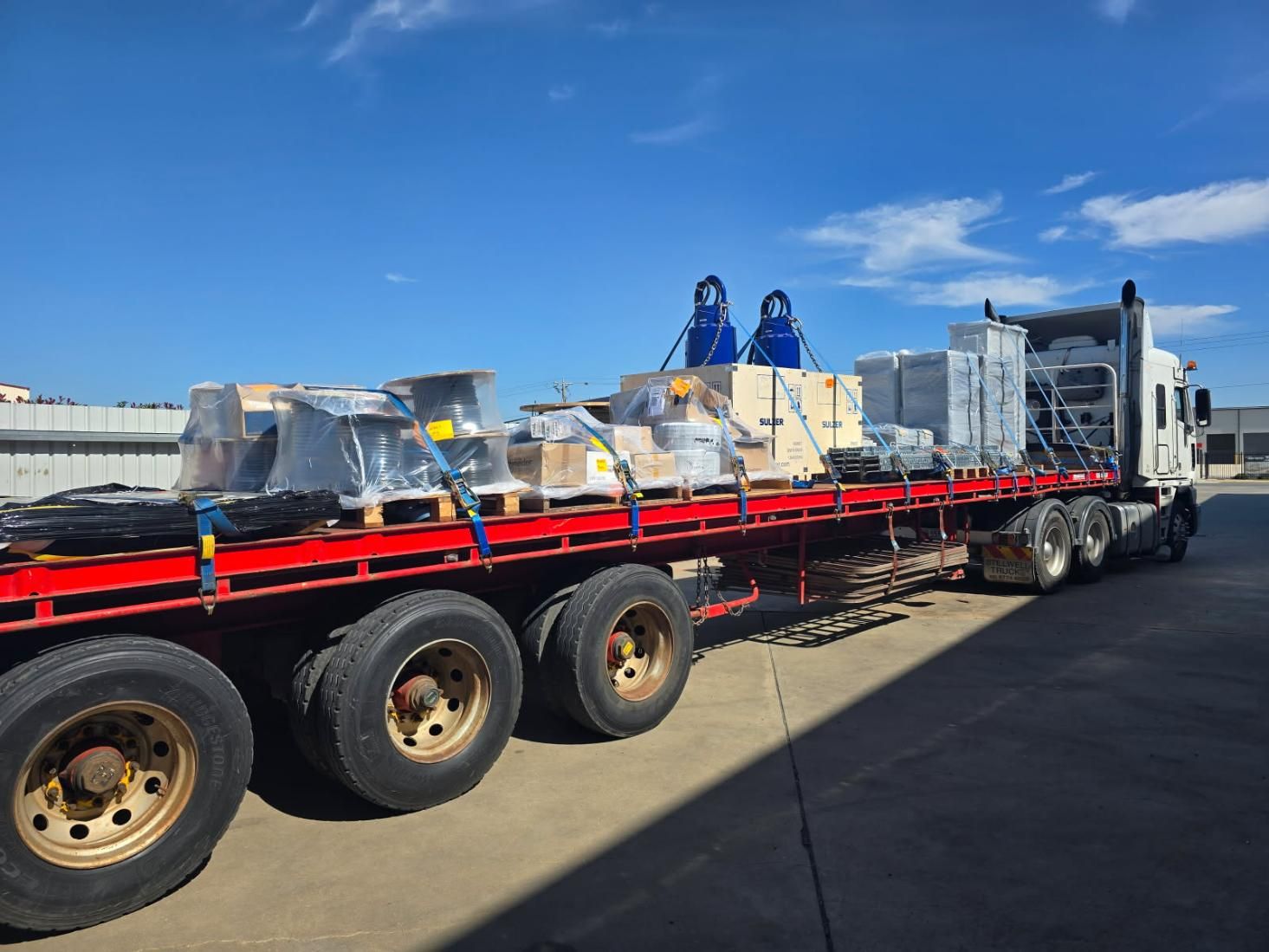 A Semi Truck is Carrying a Lot of Cargo on a Flatbed Trailer — Goulburn Transport In Brisbane, QLD